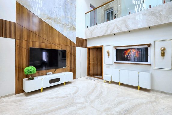 The same room built — the timber panel, the television and the white console in the positions the drawing put them, under the balcony.